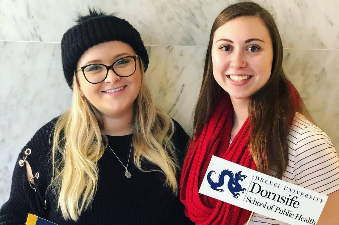 Alumni smiling with Dornsife photo prop